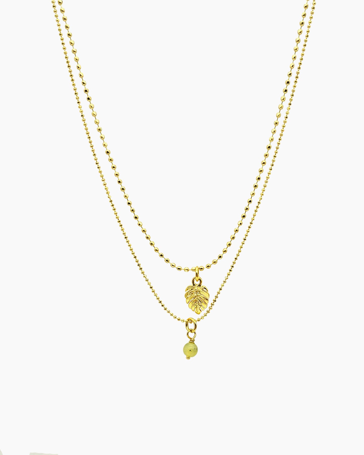 gold pvd plated double-strand faceted ball chain necklace with tiny monstera leaf charm.