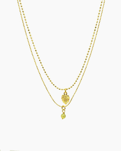 gold pvd plated double-strand faceted ball chain necklace with tiny monstera leaf charm.
