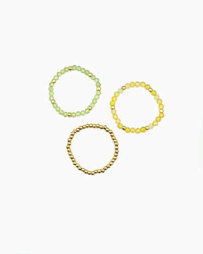 set of three stretch beaded rings in faceted peridot, yellow opal, and gold beads