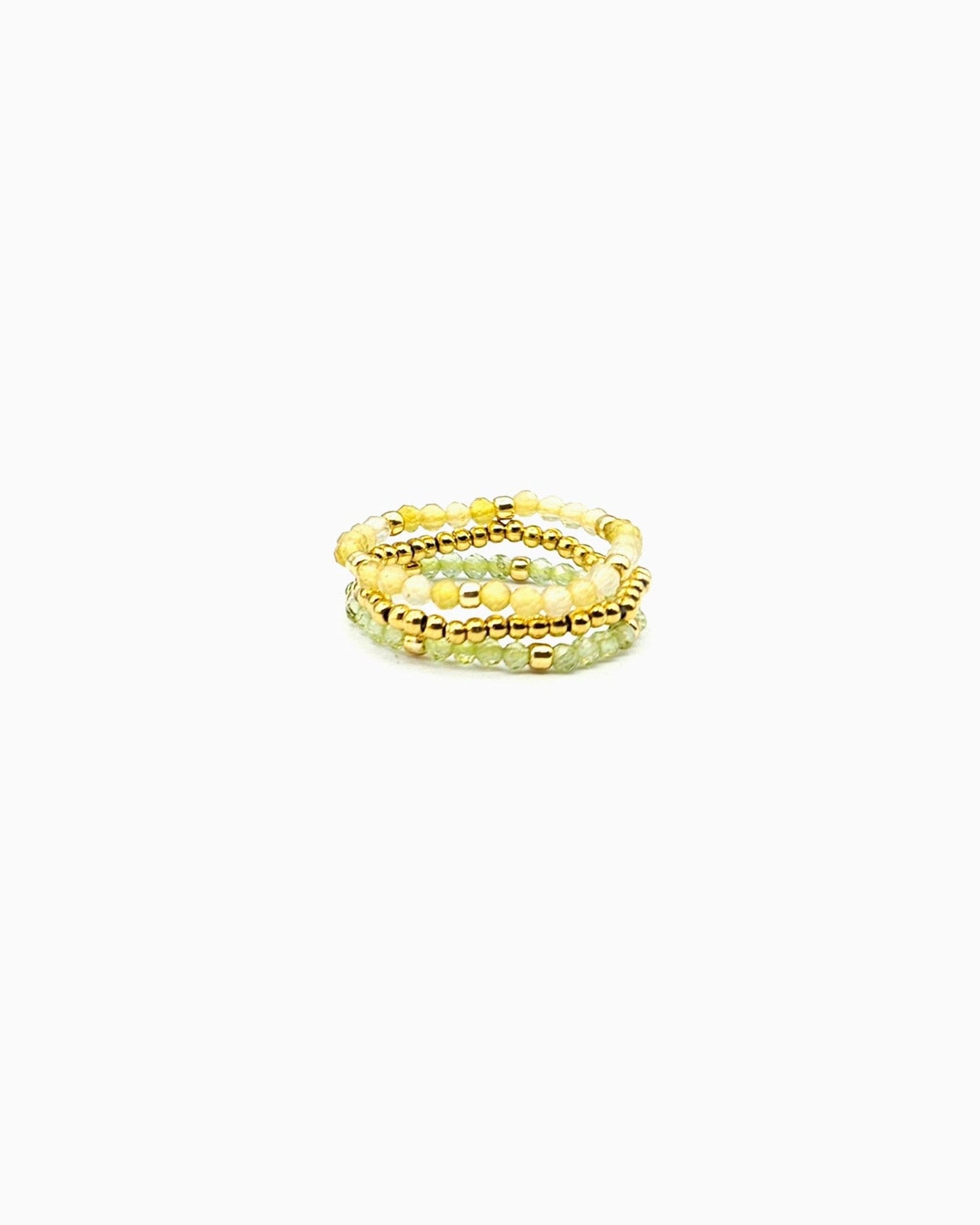 set of three stretch beaded rings in faceted peridot, yellow opal, and gold beads