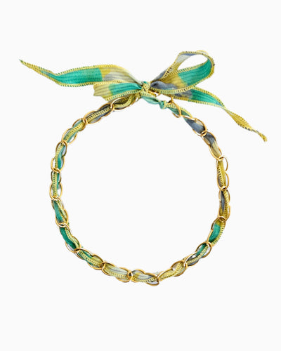 Gold chain necklace with silk ribbon woven through links