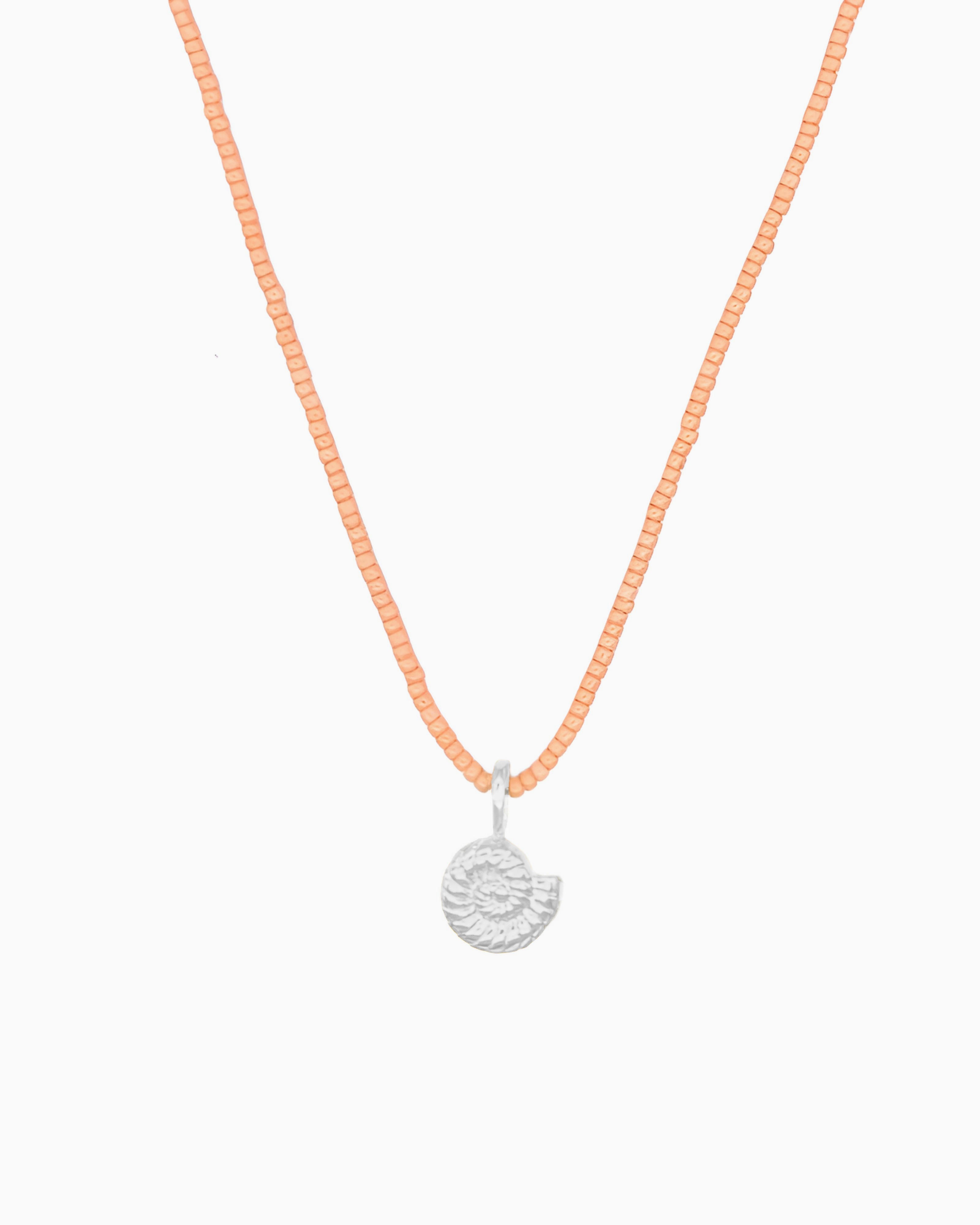 Peach Coral Nautilus Necklace featuring a delicate curb chain strand, peach coral Miyuki seed bead strand, and removable nautilus clip-on charm in silver