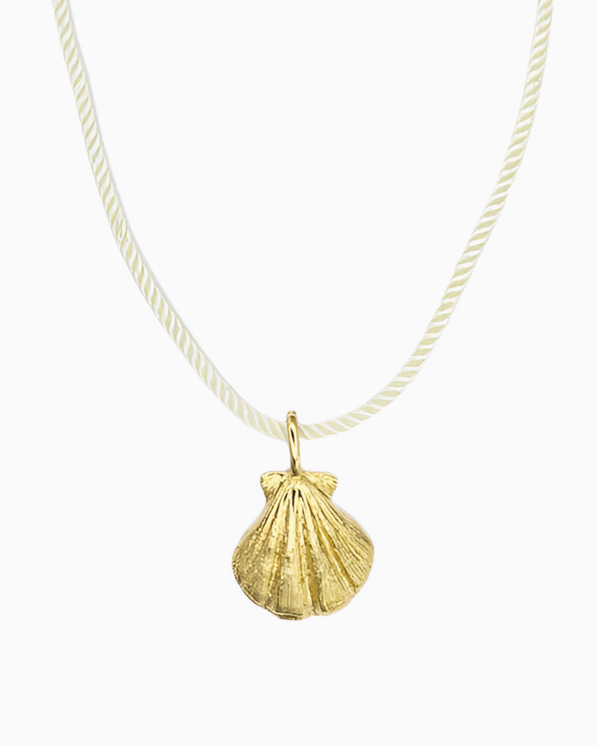 Ivory cord necklace featuring a detailed seashell clip-on charm inspired by a shell found along the shore.