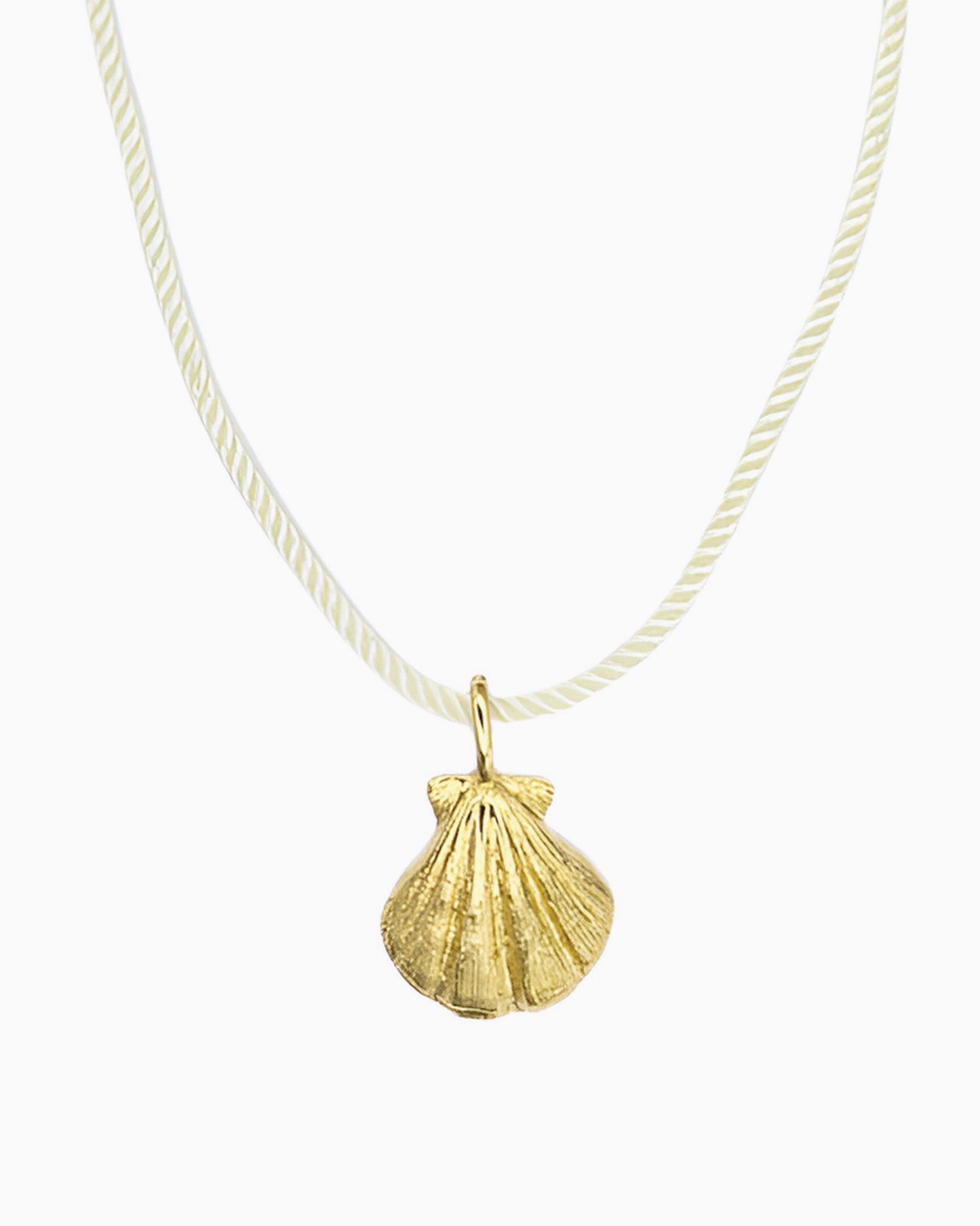 Ivory cord necklace featuring a detailed seashell clip-on charm inspired by a shell found along the shore.