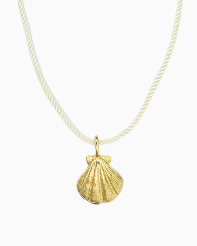 Ivory cord necklace featuring a detailed seashell clip-on charm inspired by a shell found along the shore.